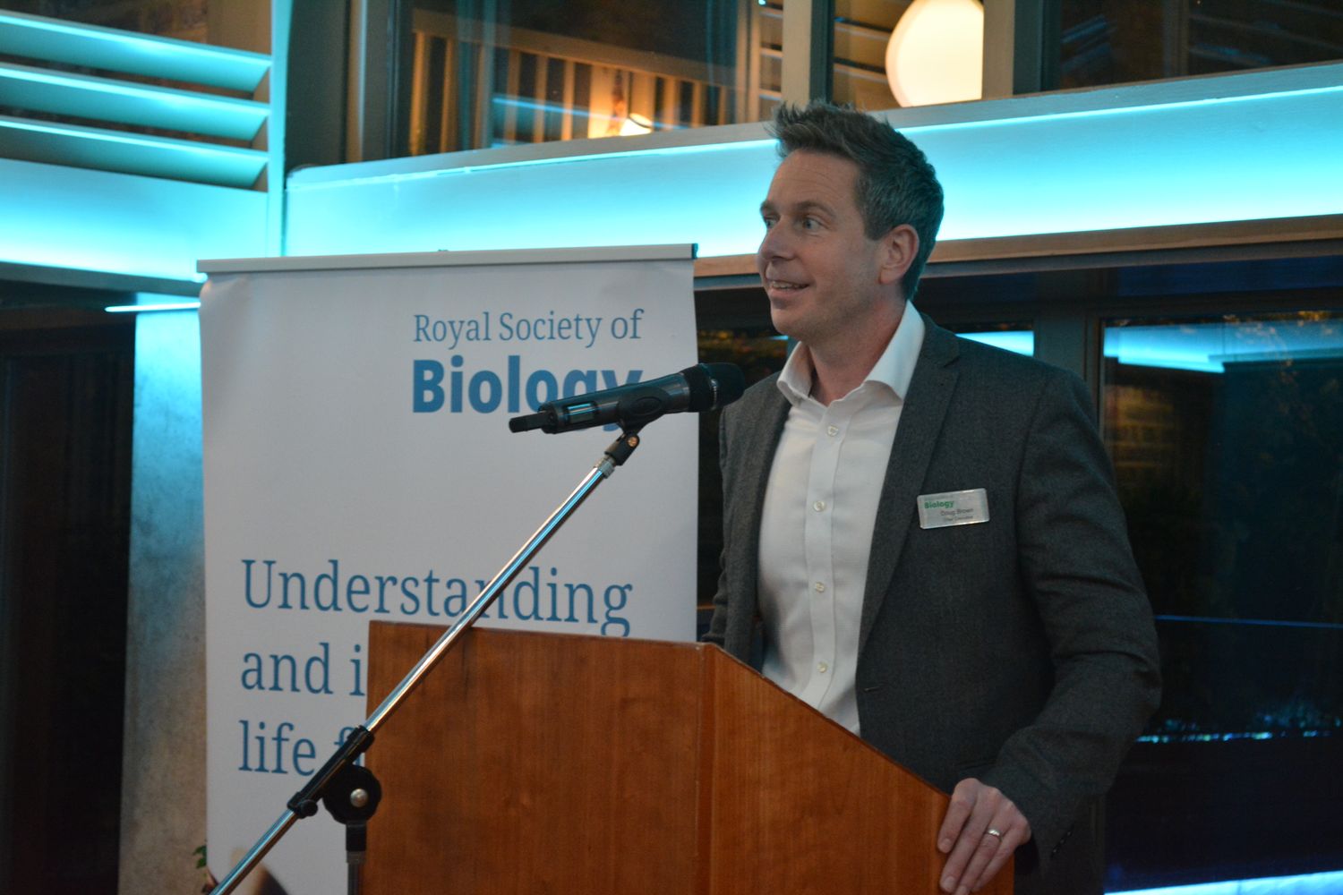 Dr Doug Brown giving speech at lectern in front of RSB banner